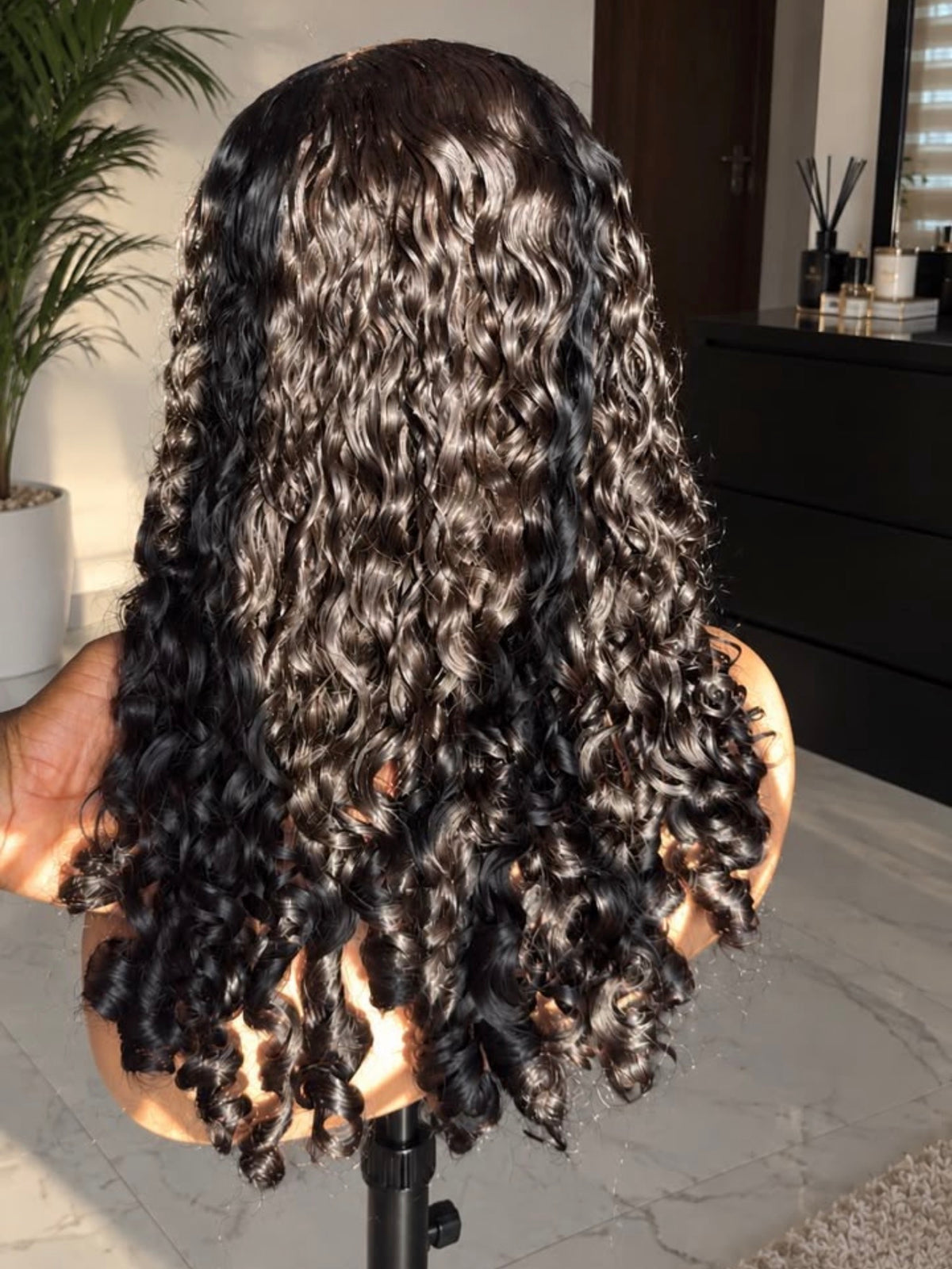 Caribbean Curly frontal wig on a mannequin head, showing defined spiral curls